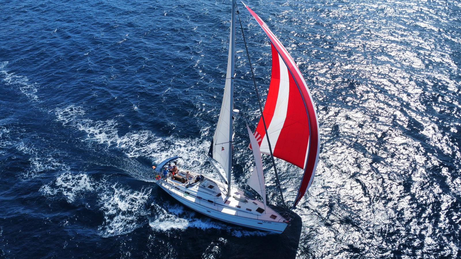 Bavaria 50 unter rot-weißem Spinnaker, Drohnenaufnahme
