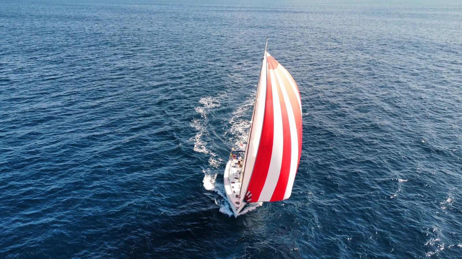 Bavaria 50 unter rot-weißem Spinnaker
